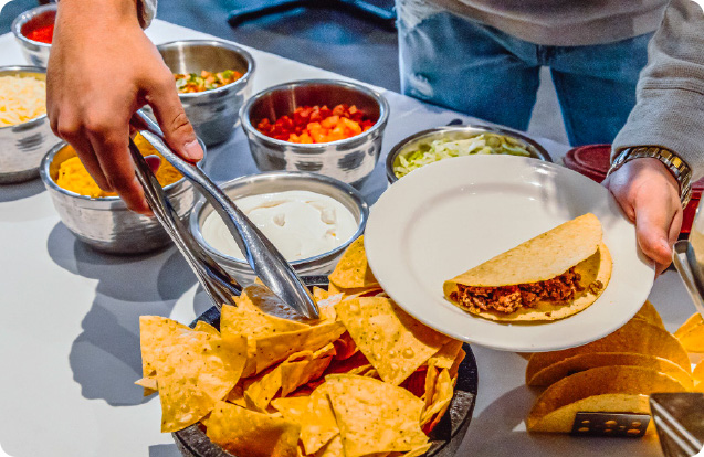A guest serving themselves from a catered Tex-Mex spread